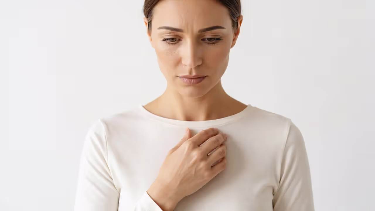 Woman checking skin sensitivity around chest area before hair removal